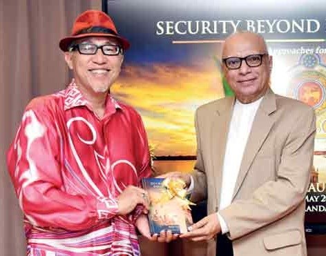 Mahil Dole presenting Security Beyond Enforcement to the High Commissioner of Malaysia at the book launch